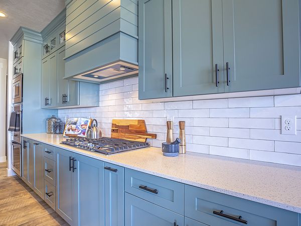 Kitchen with white subway tile backsplash, blue-gray cabinets and quartz counters